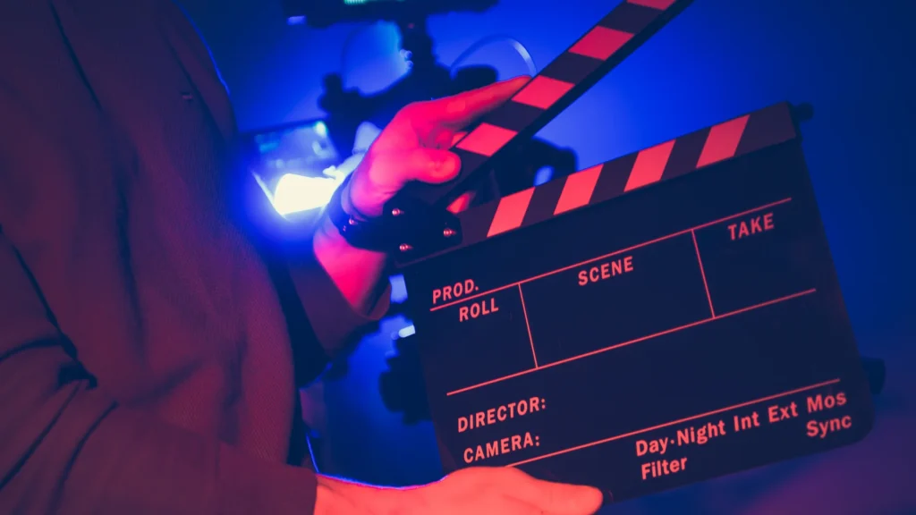Filmmaker preparing clapperboard during night shoot in retro style