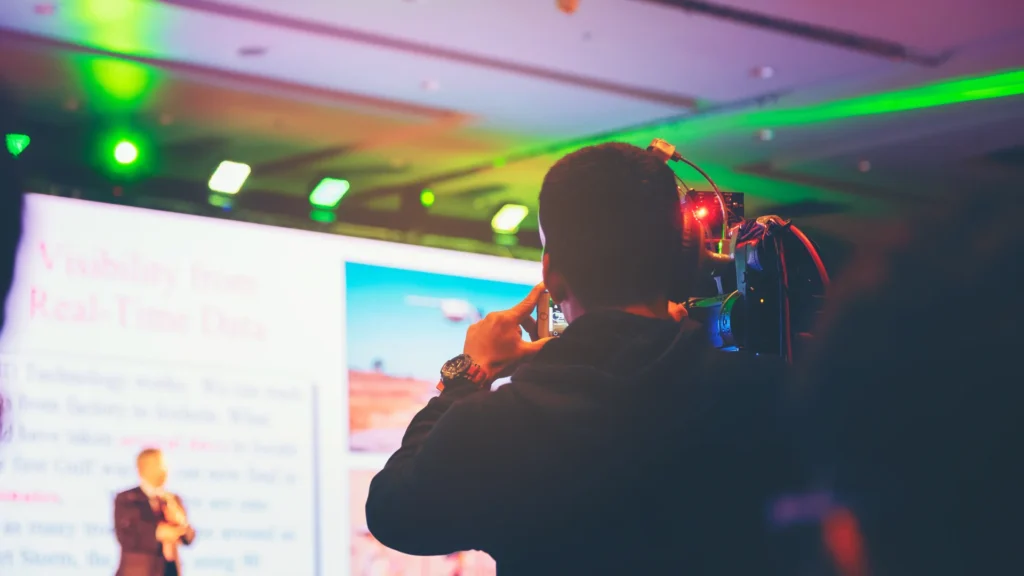Video camera recording seminar or workshop event presentation